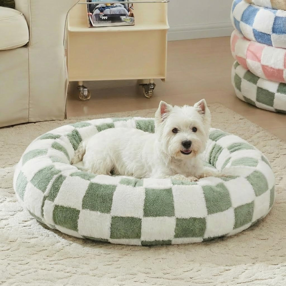 Cama redonda Ohocut para perro con cuadros verde salvia, ambiente cálido.