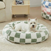 Cama redonda Ohocut para perro con cuadros verde salvia, ambiente cálido.