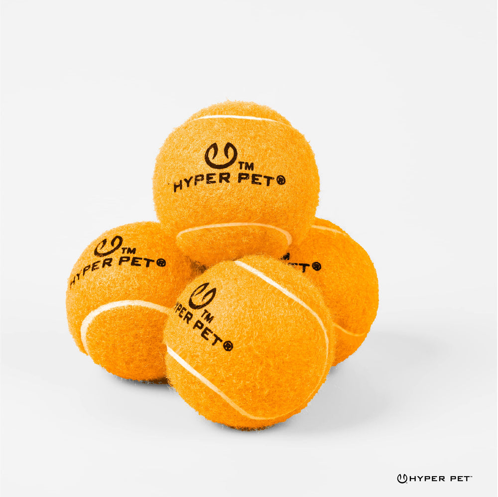 Pelota Hyper Pet Tenis en jardín, fácil de localizar entre la hierba.