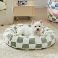 Cama redonda Ohocut para perro con cuadros verde salvia, ambiente cálido.