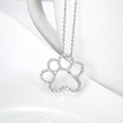 ONEFINITY detalle arte huella de perro en plata, enfoque artesanal que destaca.