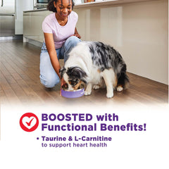 Perro pequeño disfrutando Wellness Bowl Boosters, ideal para variedad en su dieta.